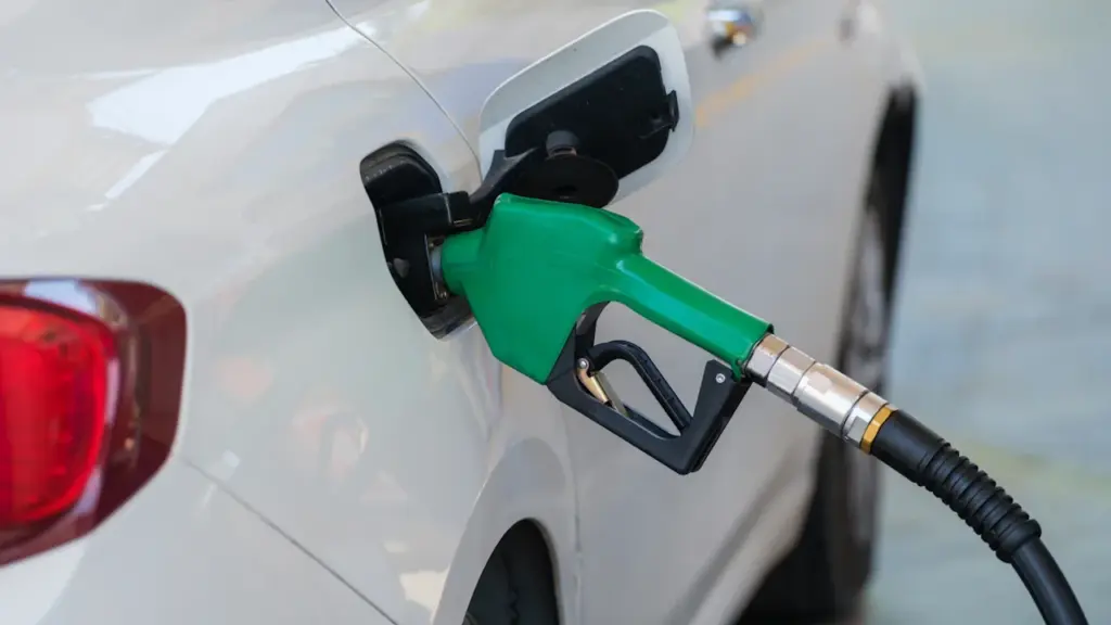 Zapfpistole beim Betanken eines weißen PKWs an einer Tankstelle für den Preisvergleich.