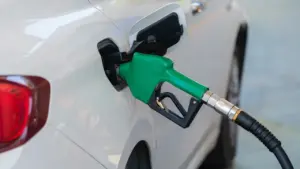 Zapfpistole beim Betanken eines weißen PKWs an einer Tankstelle für den Preisvergleich.
