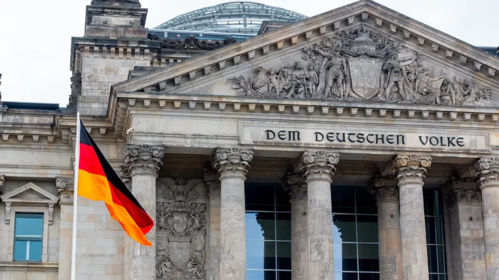 Die deutsche Flagge weht vor dem historischen Reichstagsgebäude in Berlin.