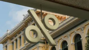Ein großes Prozentzeichen hängt vor einem historischen Gebäude, symbolisch für Zinsentscheidungen der Banken.