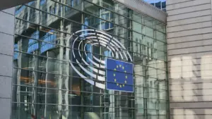 Fassade des Europäischen Parlaments mit dem EU-Symbol und Glasfront bei Tageslicht.
