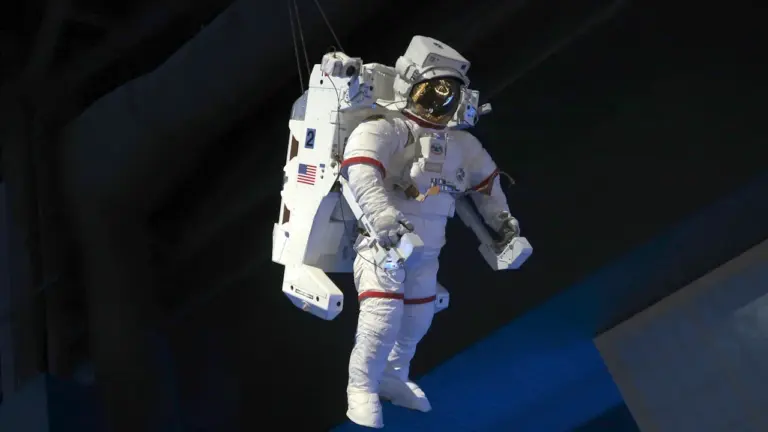 Ein weißer Raumanzug hängt frei in einer Ausstellung über Weltraumforschung.