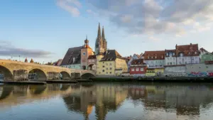 Blick über die Donau auf die historische Altstadt von Regensburg bei Abendsonne.