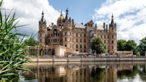 Das Schweriner Schloss bei Tageslicht direkt am Wasser in Mecklenburg-Vorpommern gelegen.