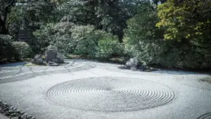Ein harmonischer Zen-Garten mit geharktem Sand und kunstvoll platzierten Steinen.