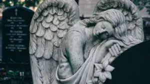 Eine melancholische Engelsstatue auf einem Friedhof als Symbol für Trauer und stille Erinnerung.