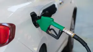 Zapfpistole beim Tankvorgang in einem weißen Auto an einer Tankstelle.