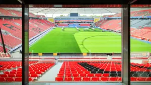 Blick aus der Kommentatorenkabine in ein leeres deutsches Fußballstadion bei Tageslicht.
