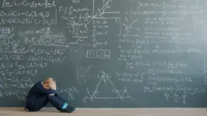 Ein Kind sitzt verzweifelt vor einer großen, mit komplexen mathematischen Formeln beschriebenen Wandtafel.