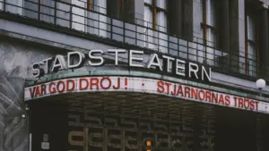 Historische Theaterfassade mit Leuchtschrift in europäischer Stadt für kulturelle Stadtführungen.