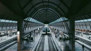 Blick auf einen modernen Bahnhof mit Zügen auf den Gleisen bei Tageslicht.
