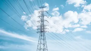 Strommast vor einem strahlend blauen Himmel als Symbol für moderne Energieversorgung in Deutschland.