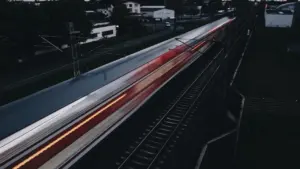 Ein vorbeifahrender Zug in Frankfurt am Main bei Dämmerung und Nacht.