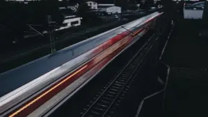 Ein vorbeifahrender Zug in der Dämmerung, der Dynamik und Zeitdruck symbolisiert.
