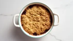 Köstlicher, ofenfrischer Birnen-Crumble in einer Auflaufform mit goldbraunen Streuseln servierbereit angerichtet.