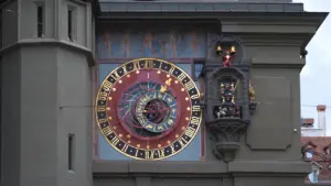 Historische astronomische Uhr an einer Fassade mit Sternzeichen und Mondphasen dargestellt.