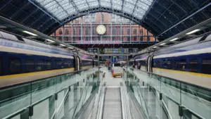 Ein moderner Bahnhof in Österreich mit einer zentralen Uhr über den Gleisen.